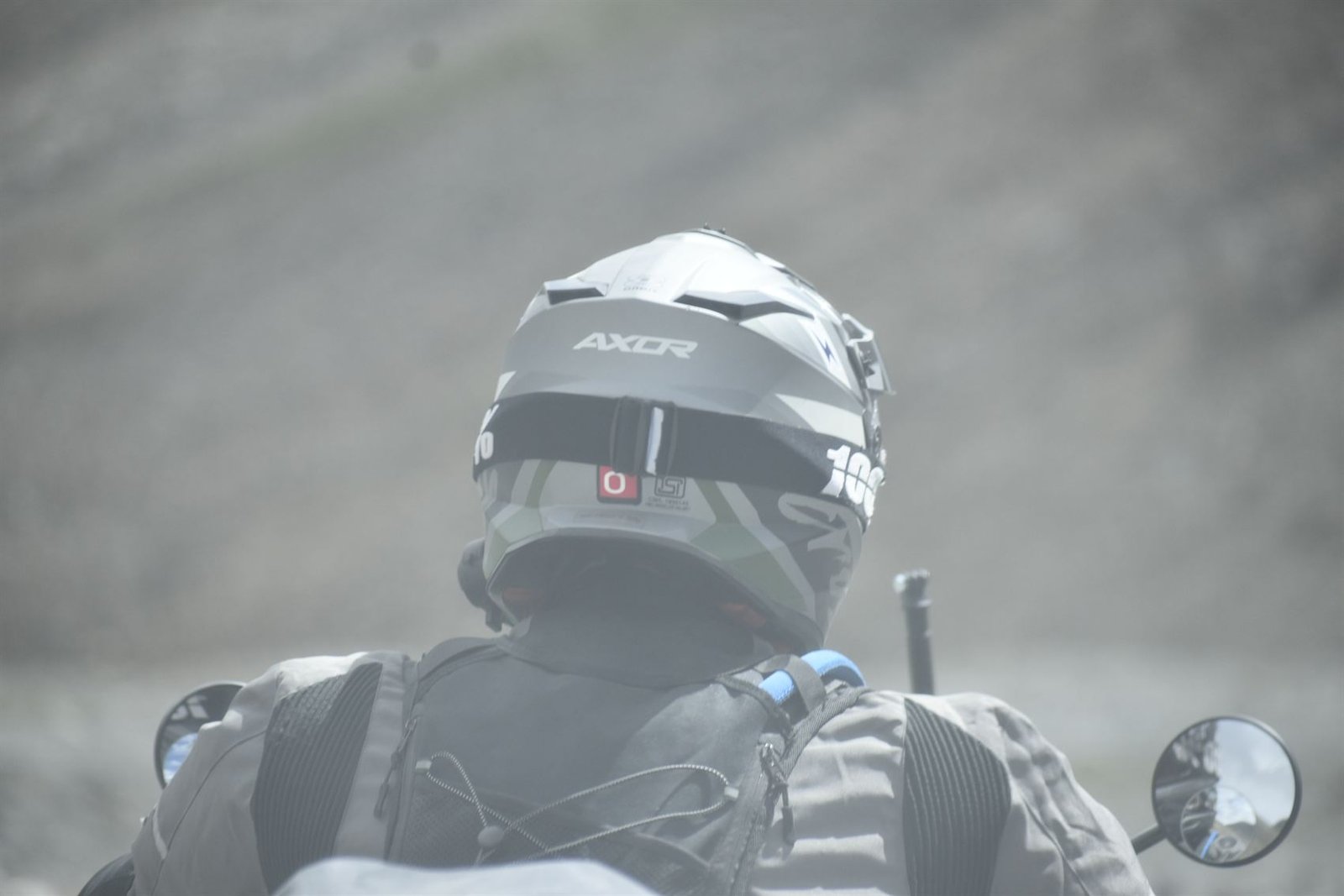 A close view over a rider's shoulder, helmet up, road ahead